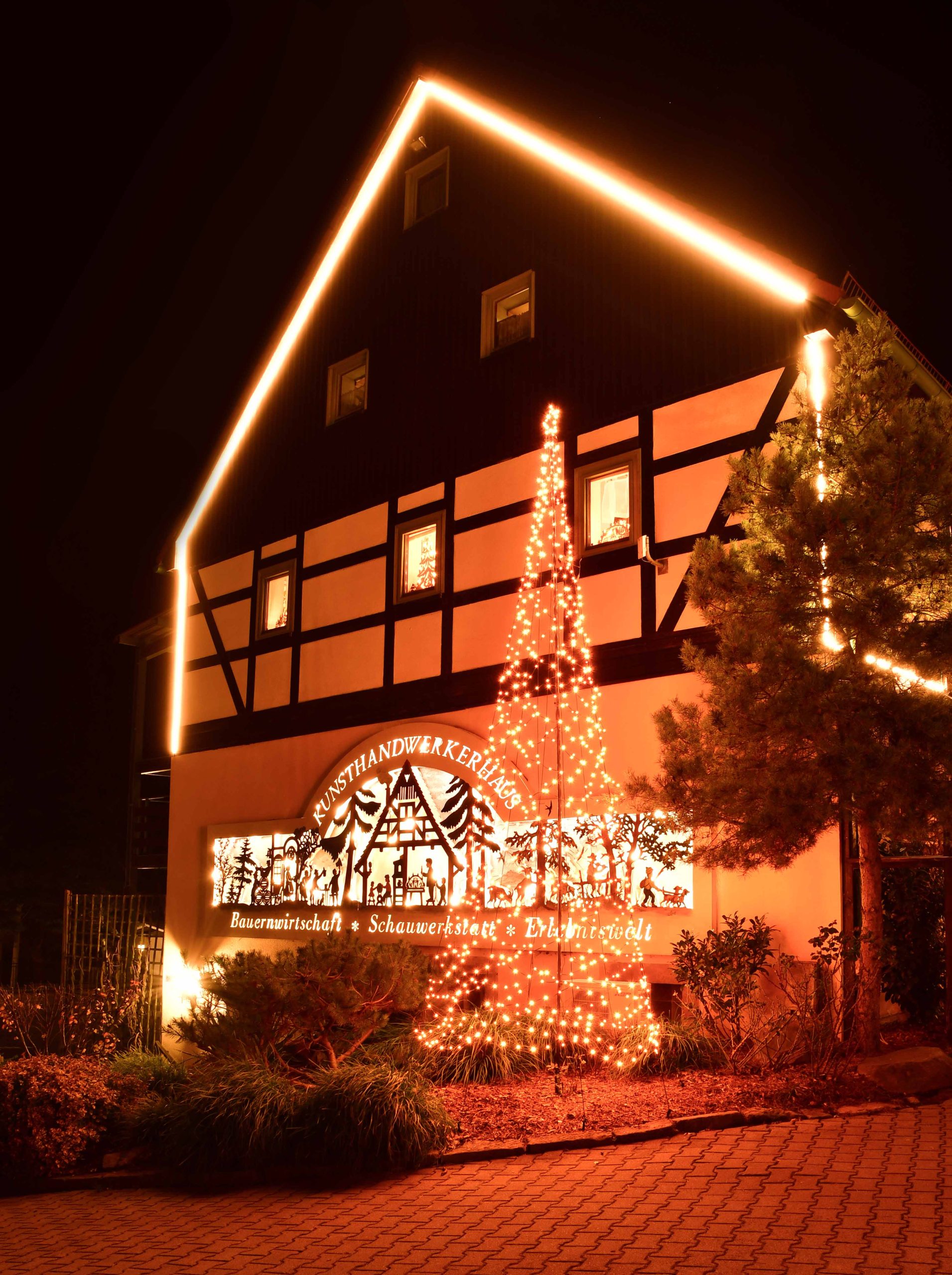 Weihnachtlich beleuchteter Giebel des RATAGS Dreiseitenhofs in Langenwolmsdorf bei Stoplen. 
